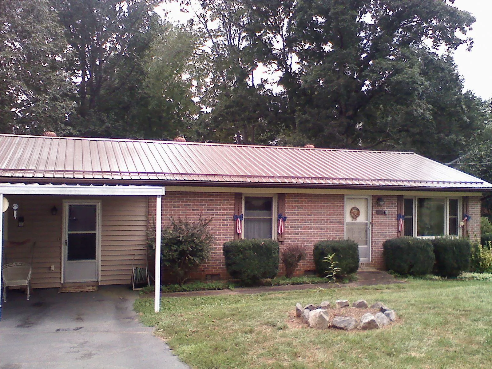 Bronze metal roof and carport on a brick ranch home — Roof Repair work by our crew in Afton